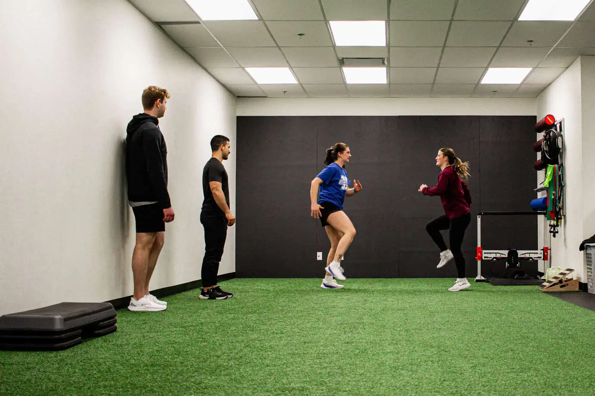 alt="Semi-private training session with a coach guiding a small group through strength exercises