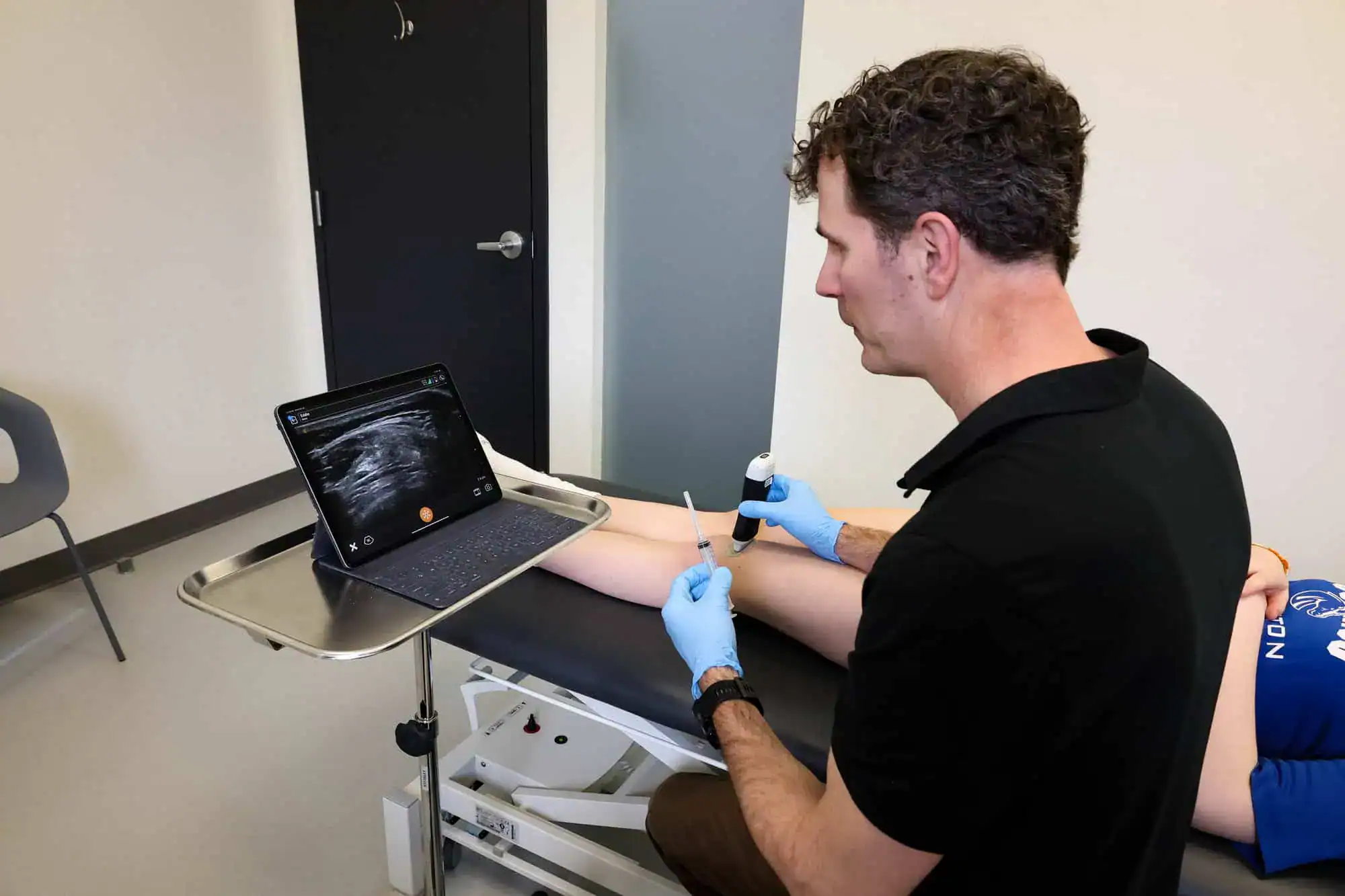Acumen Health surgeon performing an ultrasound-guided injection during patient treatment